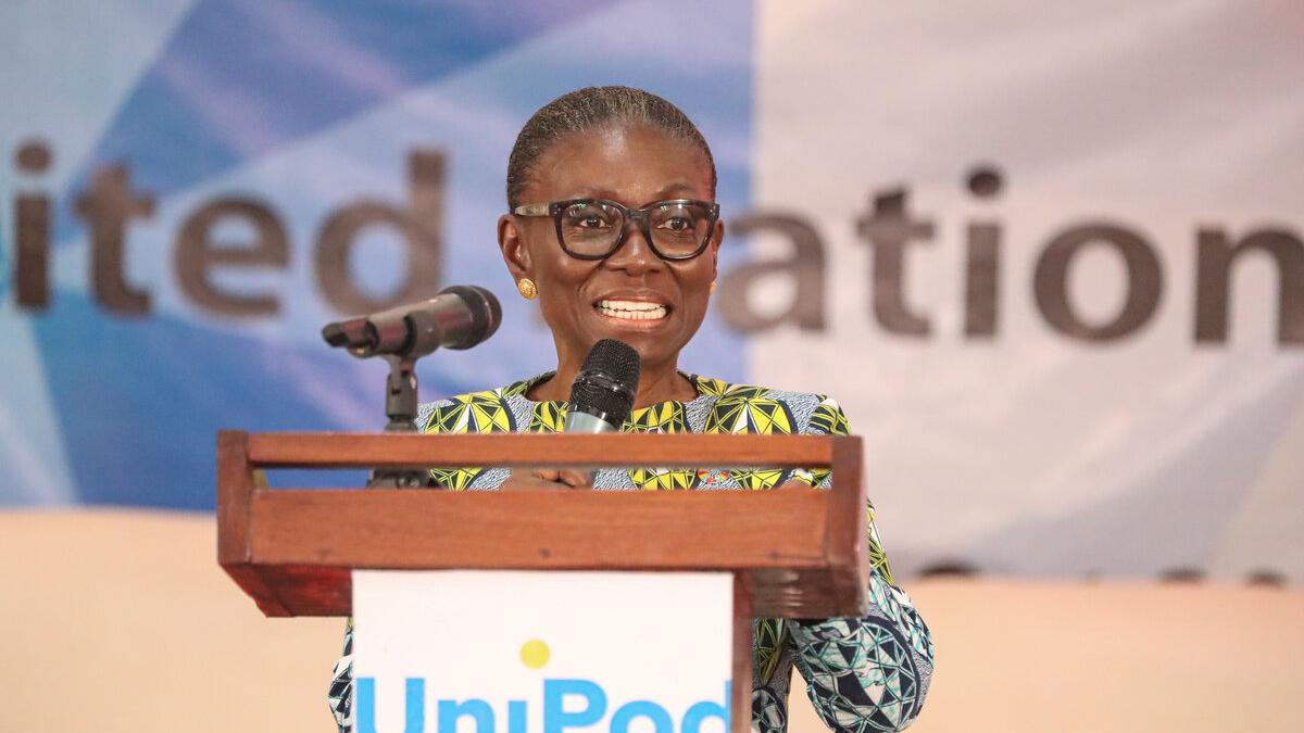 OiC SRSG Anita Kiki Gbeho speaking at a podium with a microphone during a United Nations event, with a banner in the background