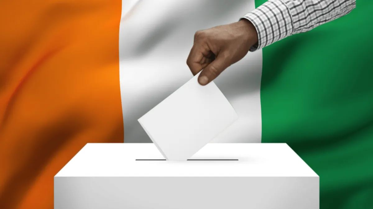 Hand placing a ballot in the ballot box