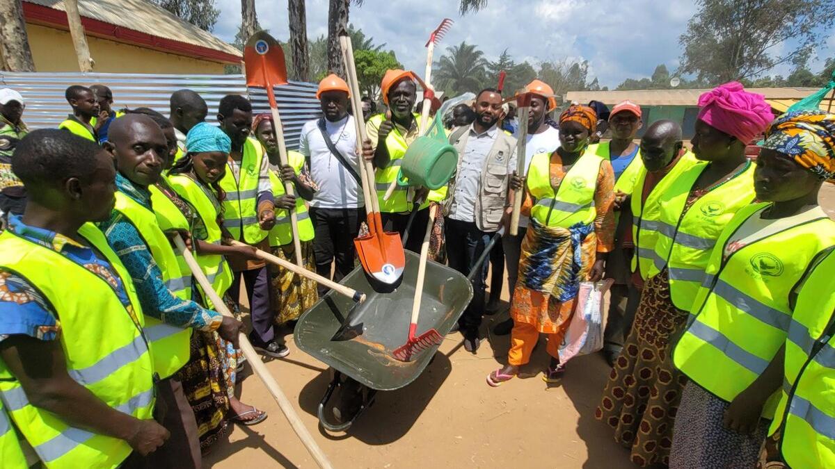 des hommes et femmes ex-combattants recoivent des outils adaptés pour cultiver dans des champs communautaires