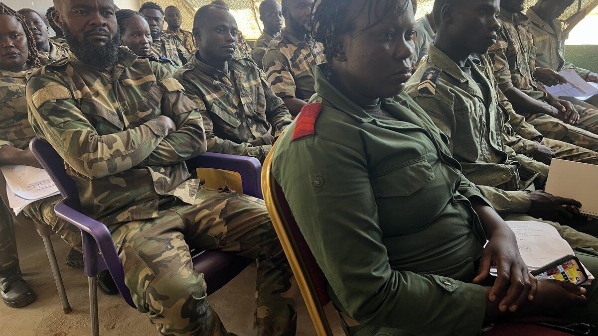 Des casques bleus sont assis pendant un événement. 