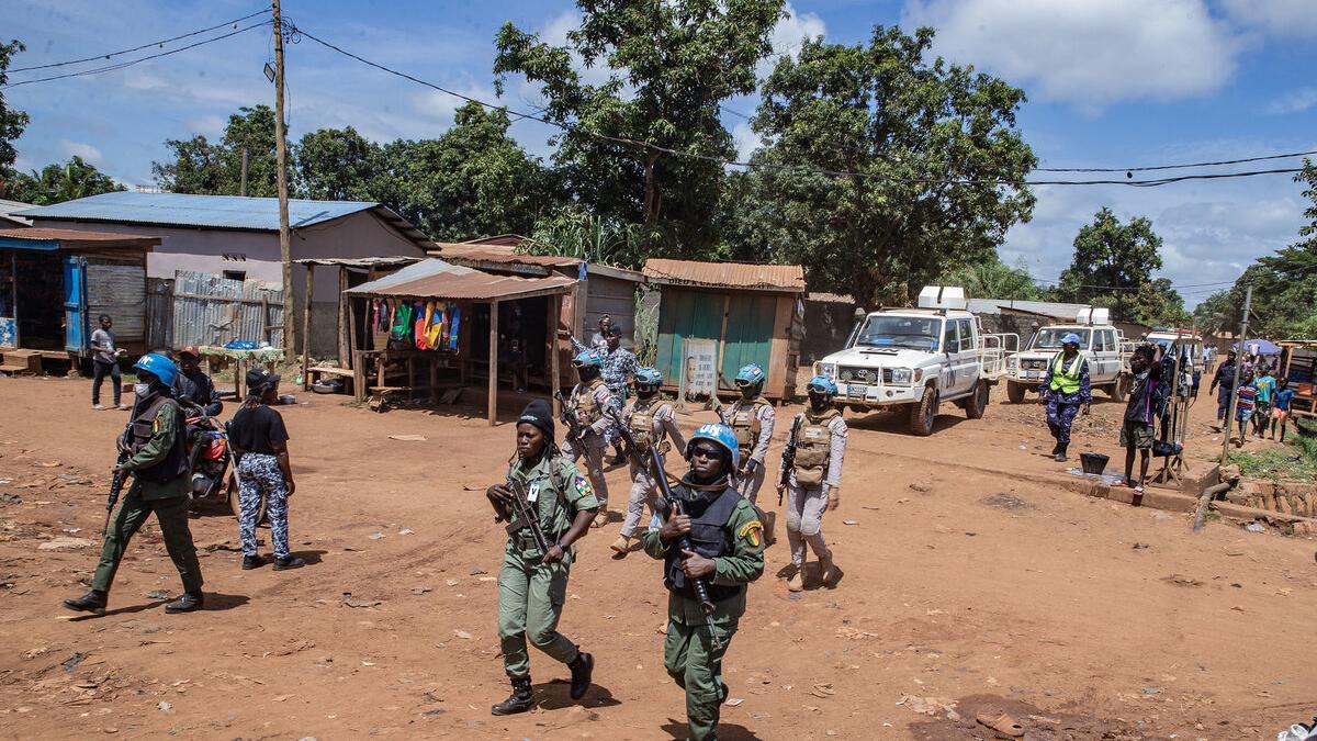 Des casques bleus marchent dans une ville. 