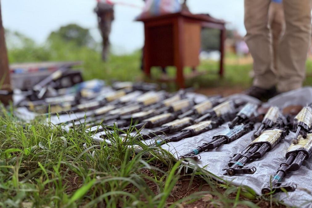 Des armes sont disposées au sol.